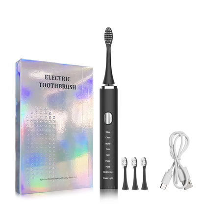 Black electric toothbrush with packaging, brush heads, and charging cable on a white background